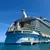 Royal Caribbean's Allure of the Seas cruise ship docked at port on a clear sunny day over blue ocean water