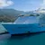 Large Symphony of the Seas cruise ship docked near lush green mountains under partly cloudy sky.