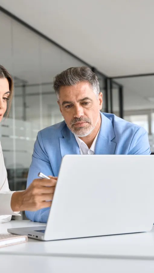 a man and a woman looking at a laptop