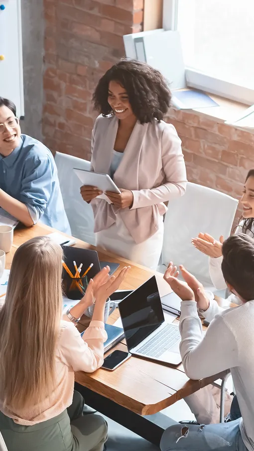 Diverse team collaborating and discussing ideas around a conference table in a modern office space.