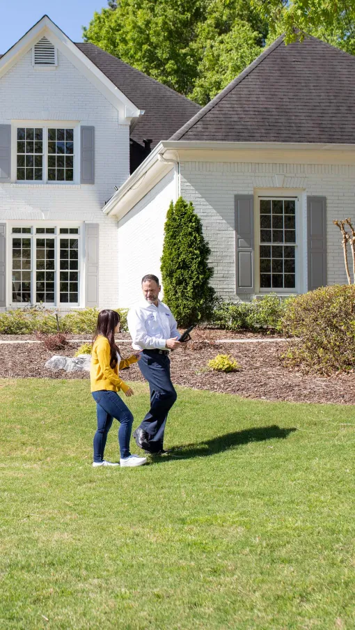 a man and a woman walking in front of a house