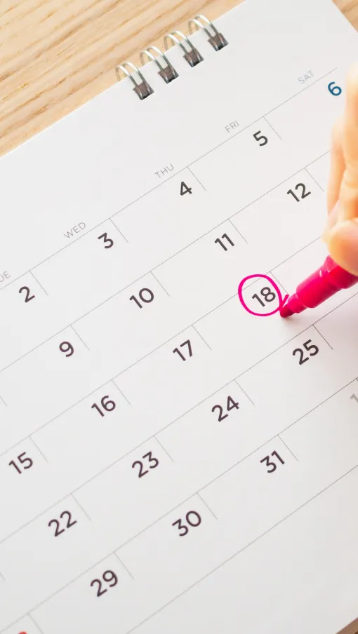 a person marking a date on a calendar