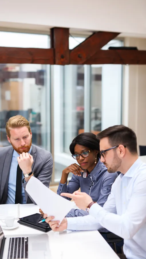 a group of people looking at a paper