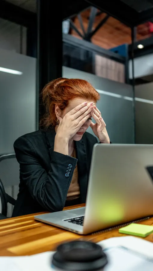 a person sitting at a desk with a laptop and a phone