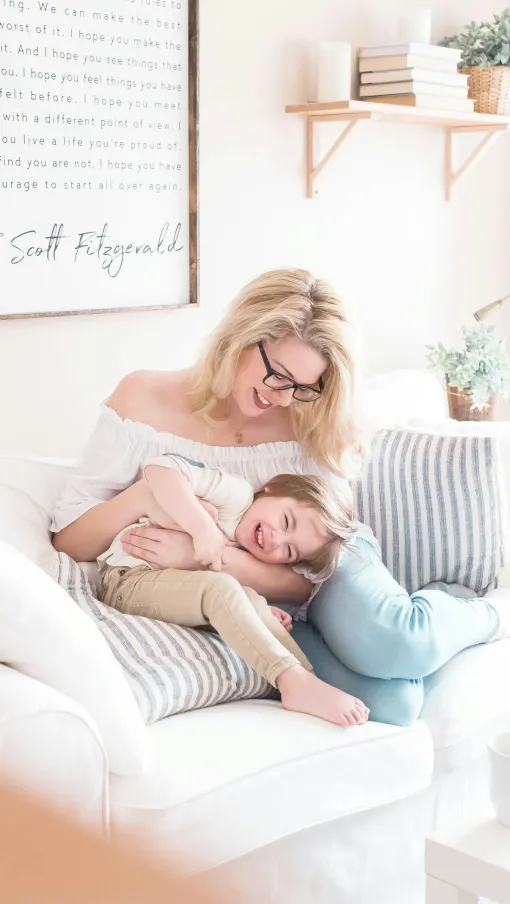 a woman holding a baby on a couch