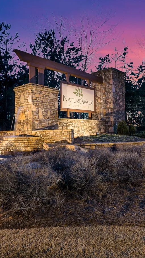 a NatureWalk entrance sign with lights shining on it