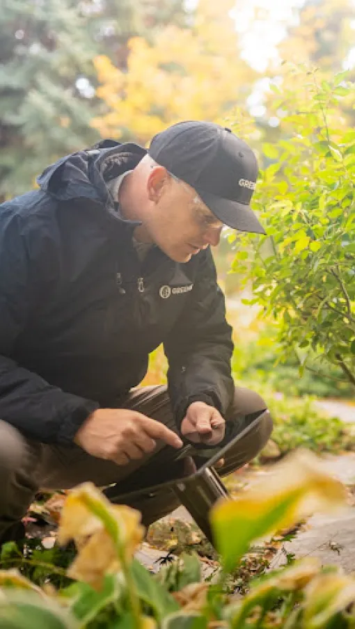 a man squatting in a garden