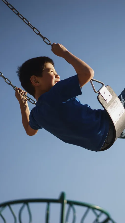 a man flying through the air on a swing