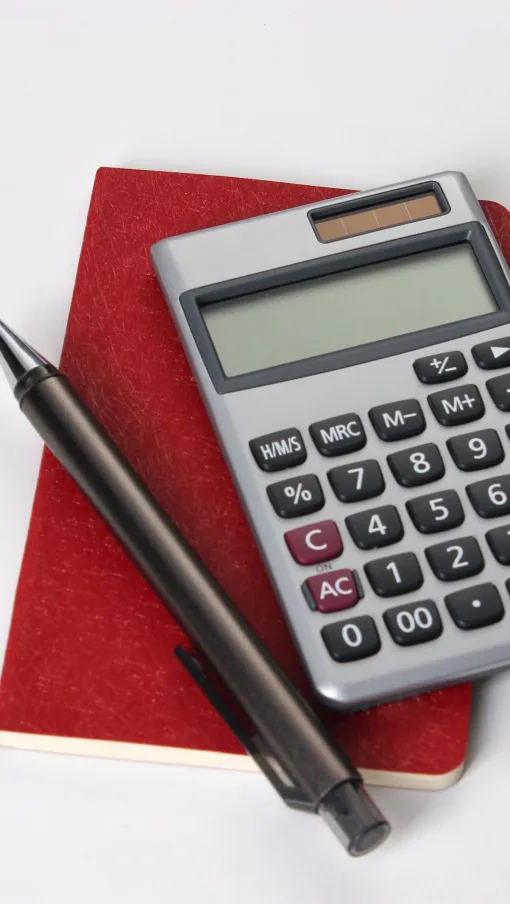 a calculator next to a pen