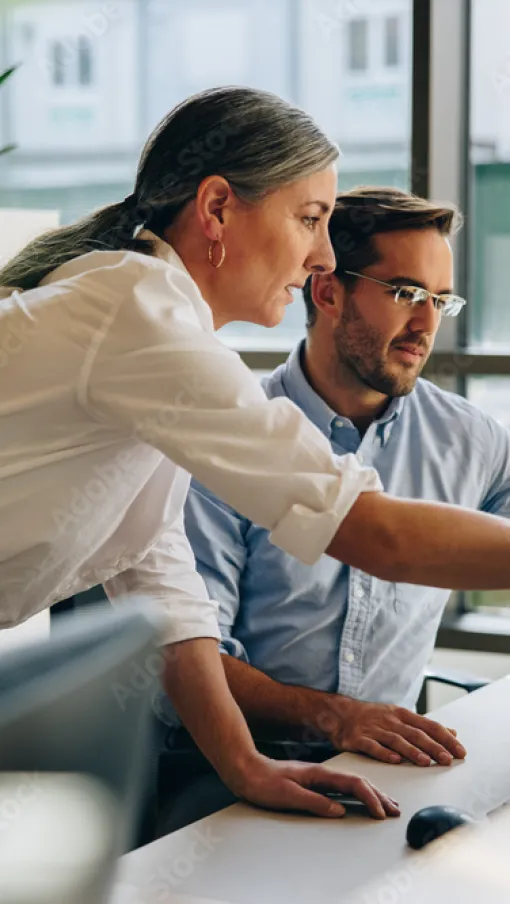 a man and a woman looking at a computer