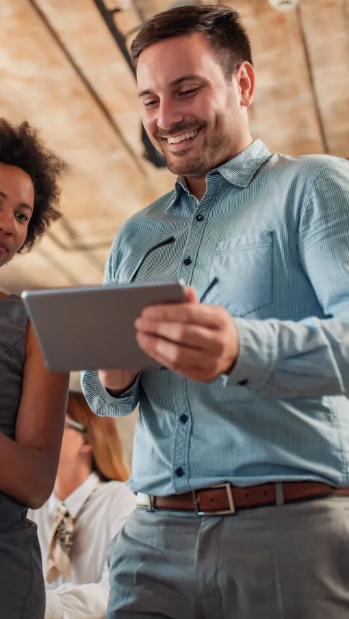 a man and a woman looking at a tablet