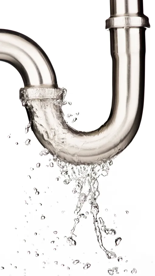 Water leaking from a stainless steel plumbing pipe joint against a white background