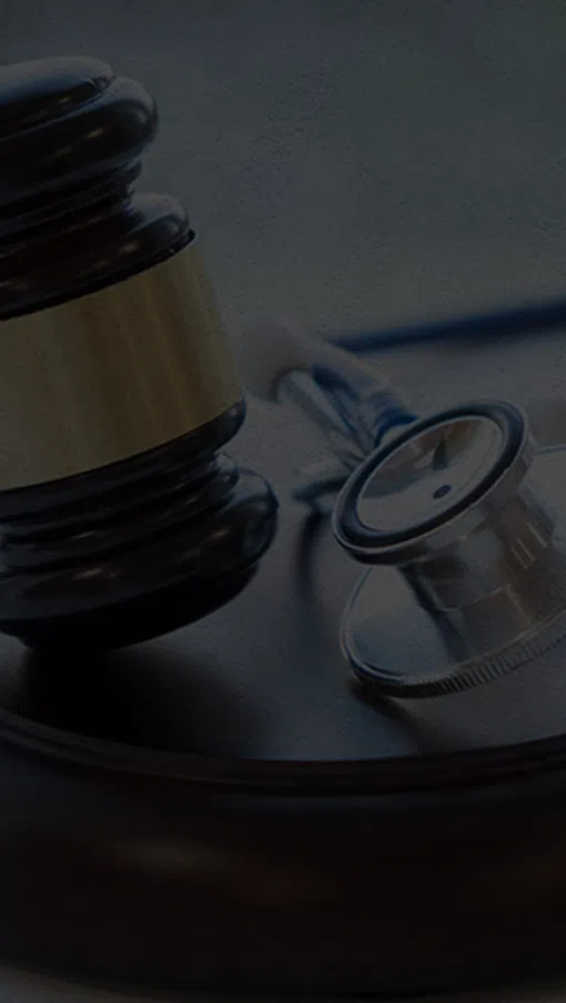 Judge's gavel and stethoscope on a wooden surface symbolizing medical law and healthcare justice.
