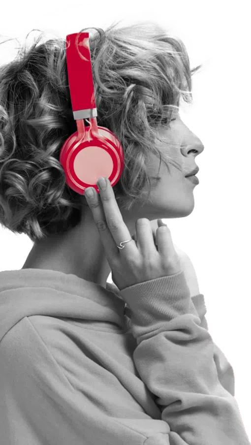 Profile of a person with curly hair wearing bright red headphones and a hoodie, touching the ear cup.