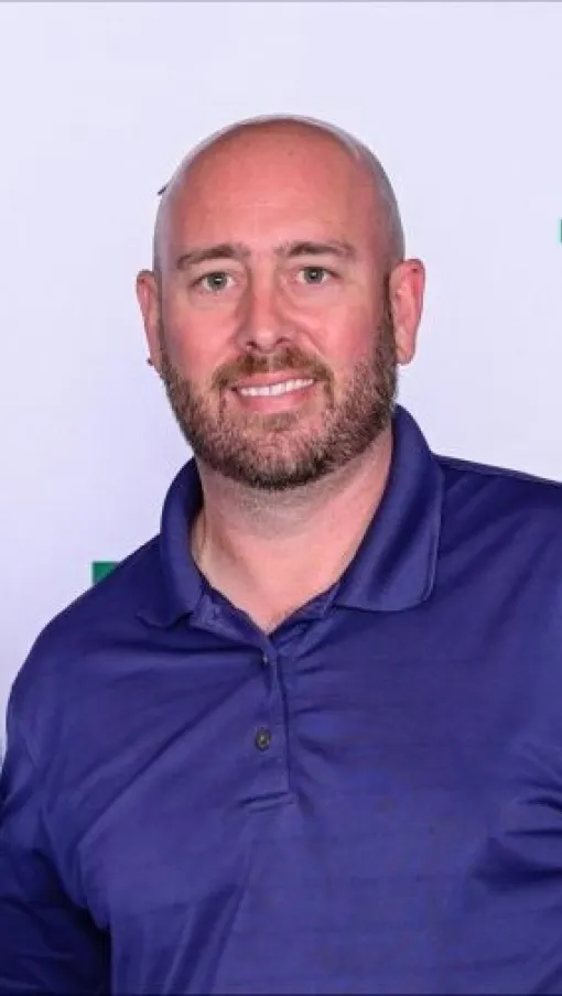 Two men smiling at a promotional event with branded backdrop for a sales presentation system.