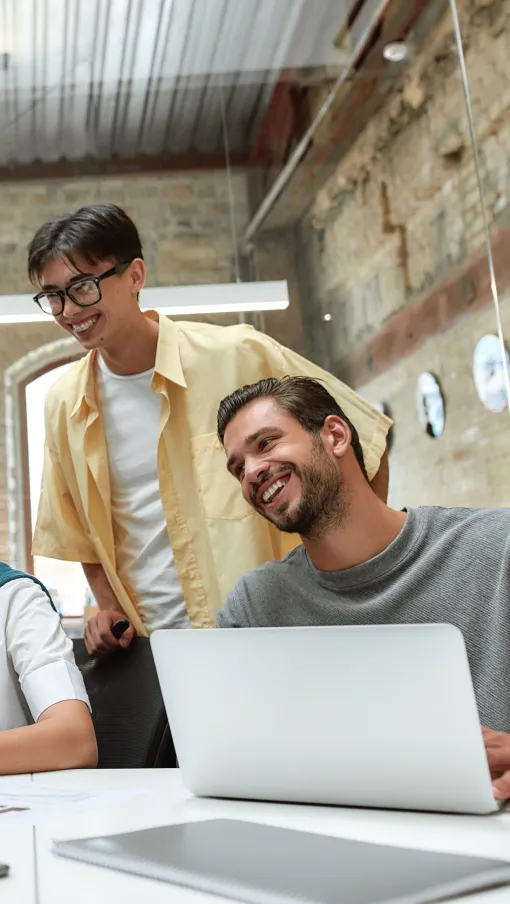 a group of people looking at a laptop