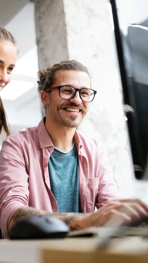 a man and a woman looking at a computer