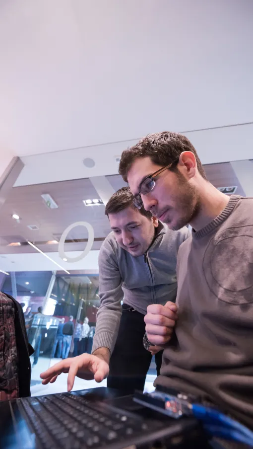 a couple of men looking at a computer screen