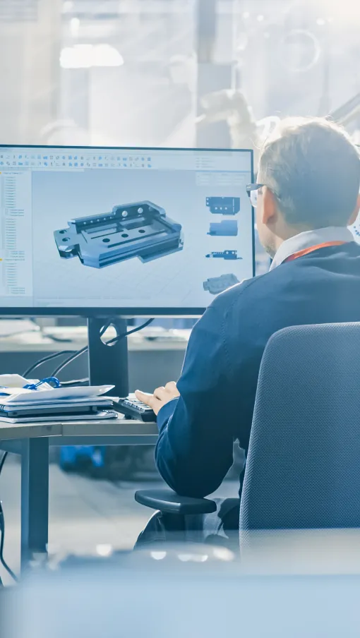 a man sitting at a desk with multiple monitors
