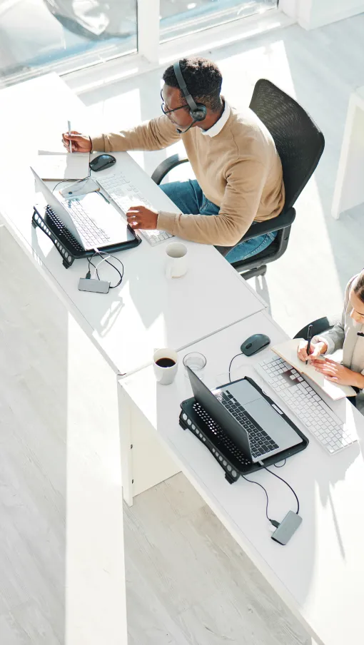 a group of people sitting at a table with computers
