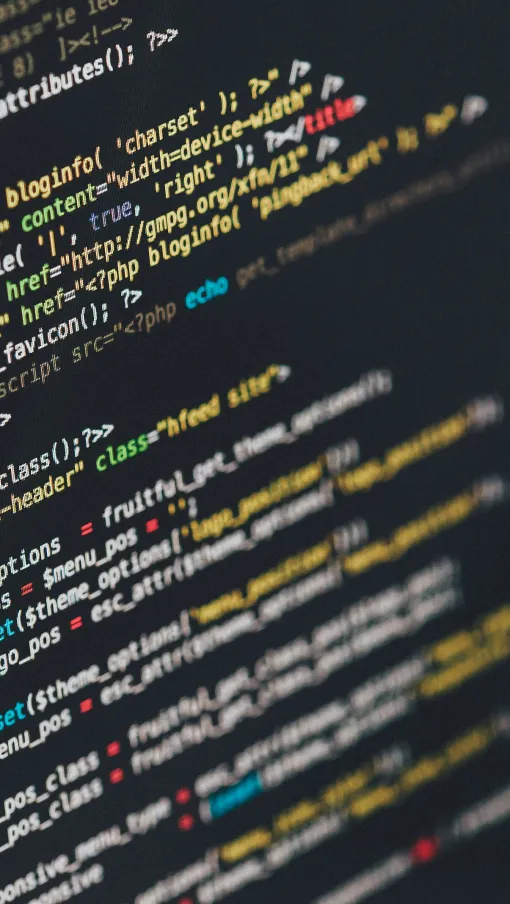 Close-up of computer screen displaying colorful lines of PHP programming code in a dark-themed editor.