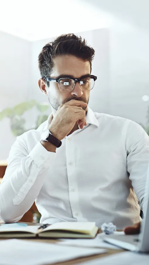 a man sitting at a desk with a laptop