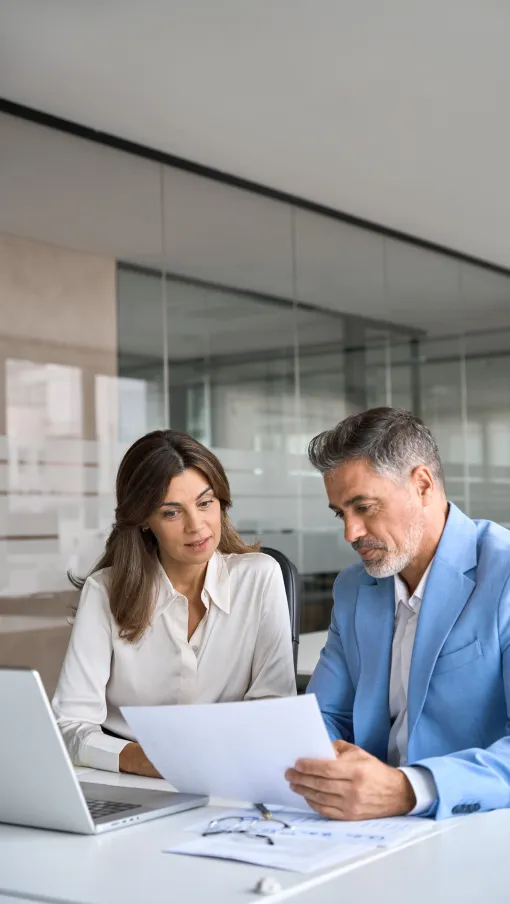 a man and a woman looking at a paper