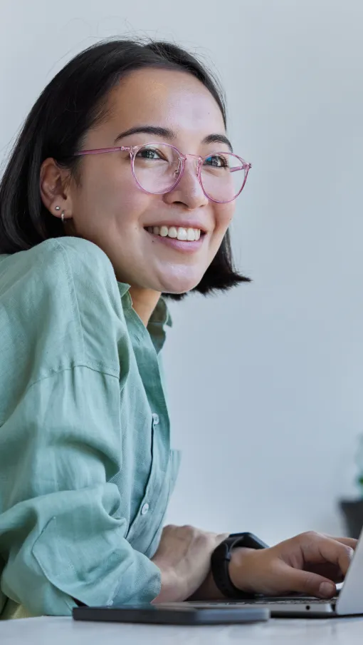 a woman smiling while using a laptop
