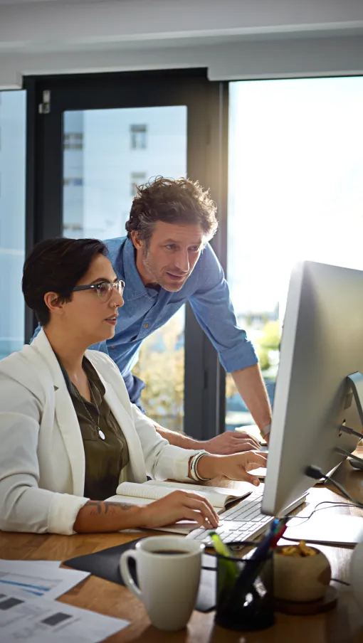 a man and a woman looking at a computer