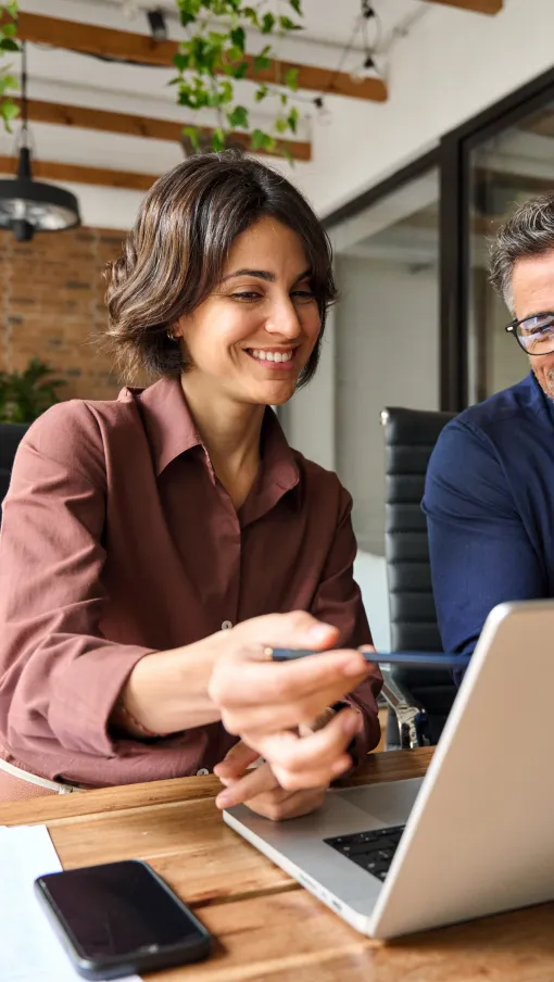 a man and a woman looking at a laptop