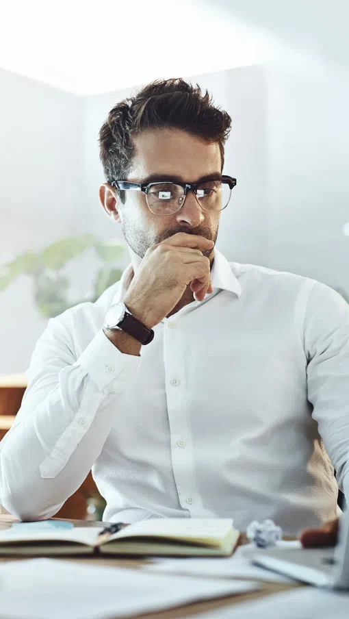 a man sitting at a desk with a laptop