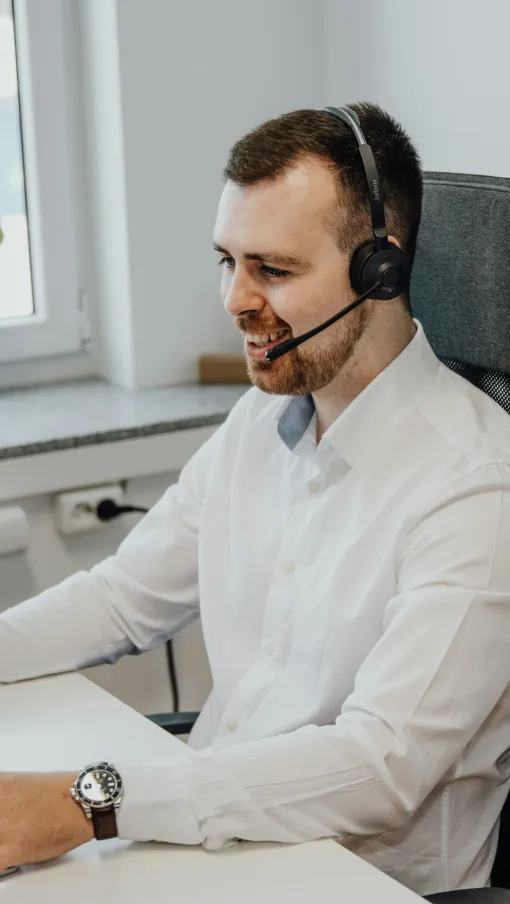 a person wearing a white coat and headphones sitting at a desk