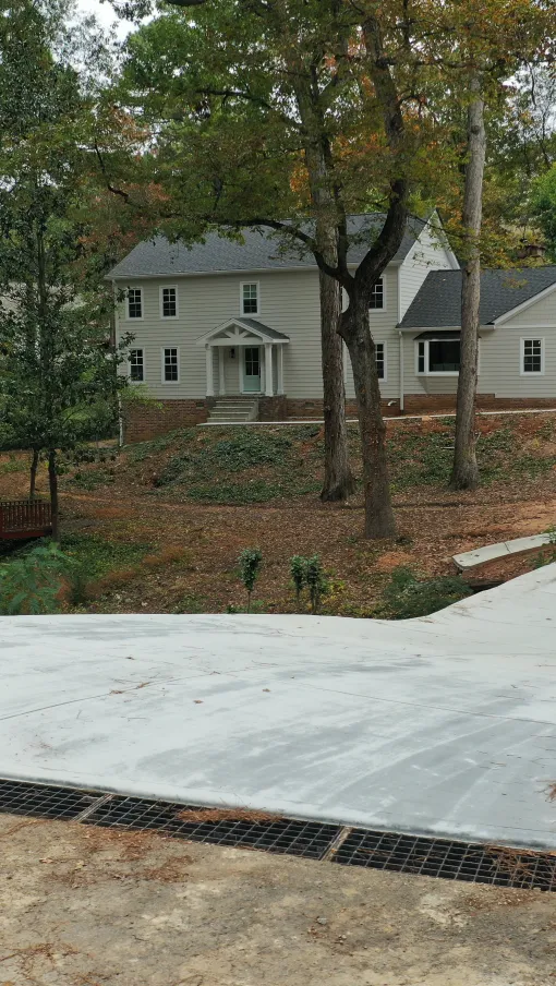 Modern home with a curved driveway surrounded by trees and autumn foliage.
