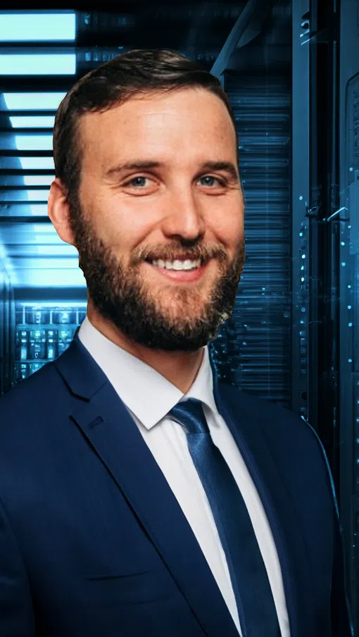 Smiling businessman in suit standing in a modern data center with server racks and blue lighting.