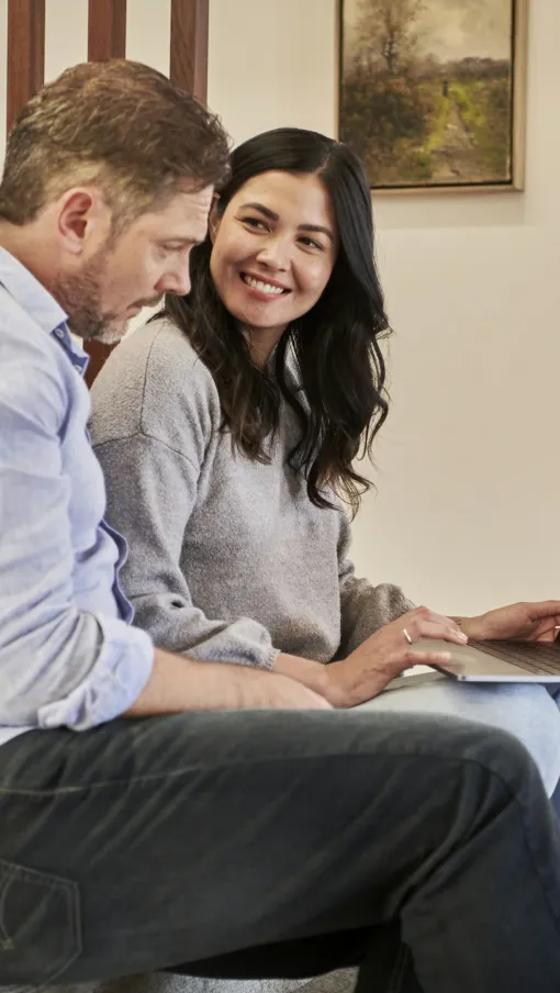 a man and woman looking at a laptop