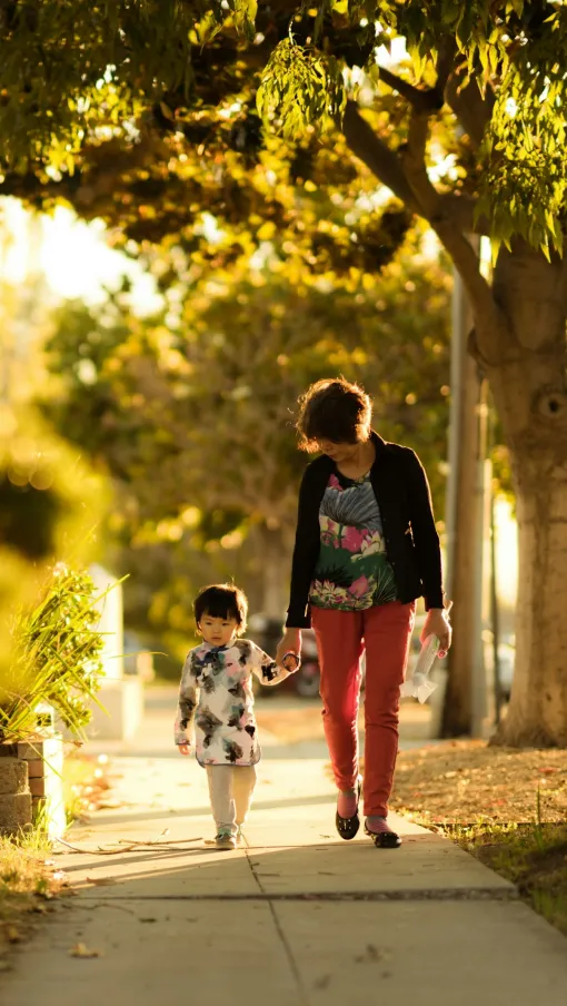 a man and a child walking on a path in a park