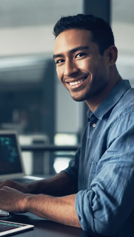 a man smiling while using a computer