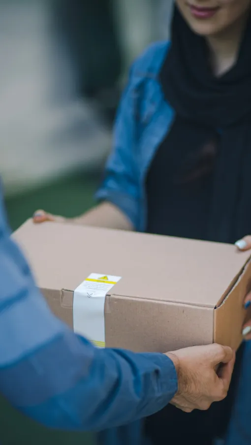 a person handing a box to a woman