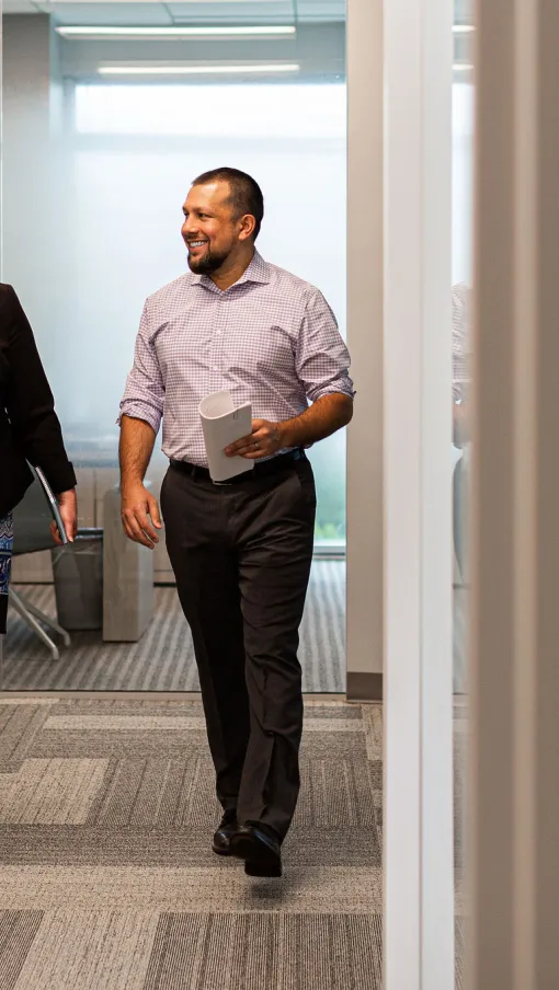 woman and man walking in an office