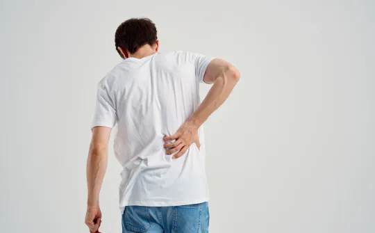 a man with his hand on his back