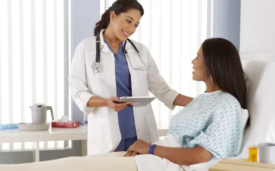 a doctor showing a patient something on the tablet