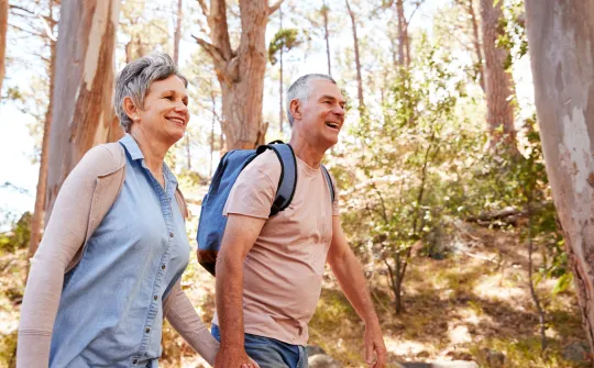 a man and woman walking in the woods