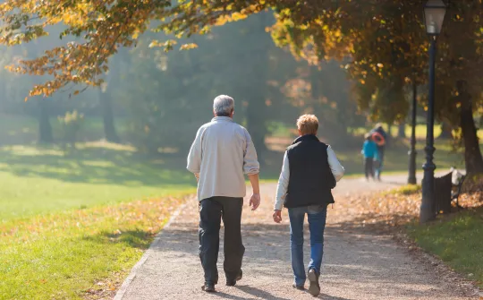 a man and a woman walking on a path in a park