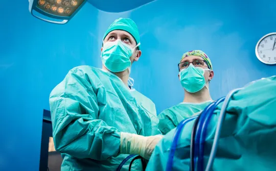 a group of surgeons in blue scrubs and masks