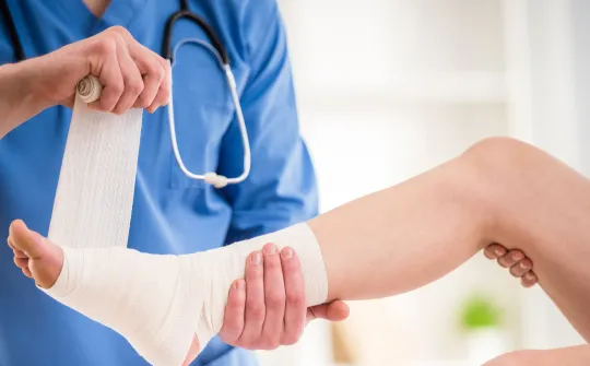 a doctor holding a patients ankle