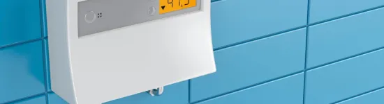 White digital thermostat mounted on blue tiled wall displaying temperature of 47.5 degrees Celsius.