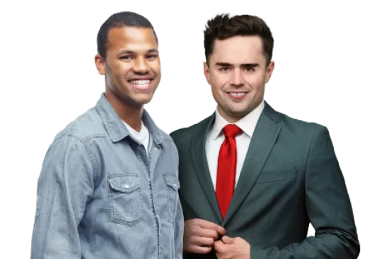 Two smiling men, one in a gray denim shirt and the other in a suit with a red tie, posing together