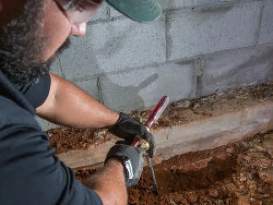 a man holding a termite injection tool