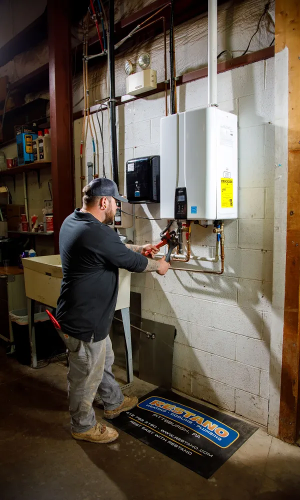 a person working on a tankless water heater
