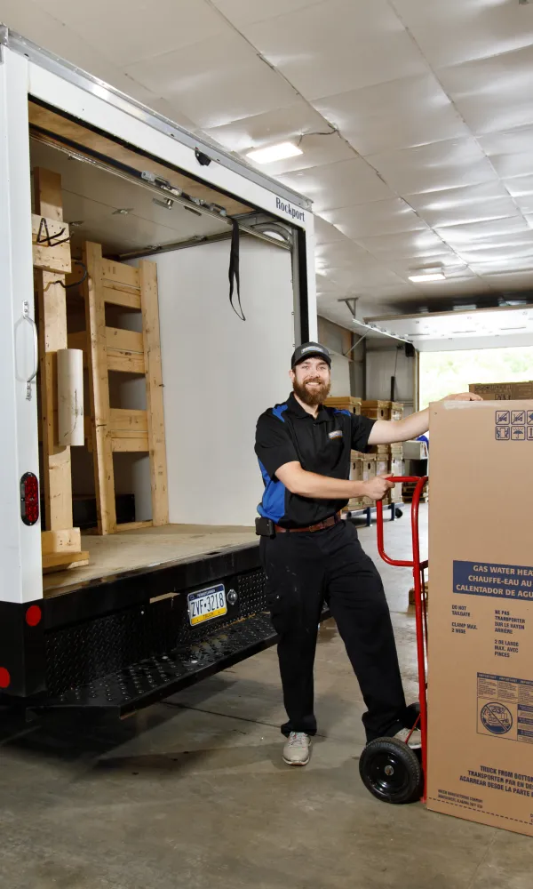 Restano Plumber loading water heater into truck